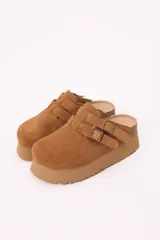 Zuecos color marrón claro de símil gamuza con plataforma liviana y doble hebilla regulable.