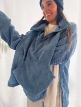 Buzo de pana fina color verde oliva, con diseño de corte holgado y mangas largas. Presenta una textura de cordón vertical característica de la pana y un pequeño parche decorativo en la parte superior de la espalda.