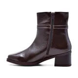 Bota corta de cuero color marrón, con taco bajo y punta cuadrada. Presenta una correa con hebilla dorada alrededor del tobillo.