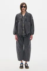 Pantalón jean slouchy de tiro medio, estilo mom, color gris oscuro con lavado suave. Presenta un bordado de estrella en el bolsillo delantero.