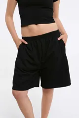 Short deportivo negro con cintura elástica y bolsillos laterales. Corte holgado a la rodilla.