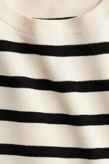 Remera de punto fino color crema con rayas horizontales negras, de manga corta y cuello redondo.