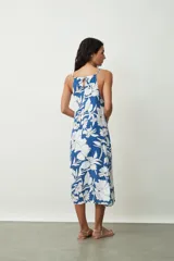 Vestido midi con estampado abstracto en tonos naranja y blanco, breteles finos y corte evasé.