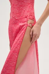 Pantalón largo de tela fluida con estampado de cebra en tonos rosa y fucsia. Tiene corte ancho y aberturas laterales con detalle de argollas.