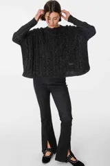 Pantalón de jean gris con corte acampanado y abertura en el ruedo.