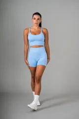 Conjunto deportivo celeste compuesto por un top con breteles finos y unos shorts de calce ajustado.