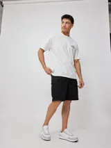 Remera blanca de algodón con cuello redondo y estampado del logo de la marca Rusty en el pecho.
