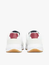 Zapatillas Tommy Hilfiger blancas con detalles en azul, rojo y suela color caramelo.
