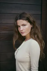 Camiseta negra de manga larga con cuello redondo y cierre frontal con botones.