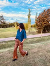 Pantalón cargo de cuero color suela, con tiro medio, corte suelto y pespuntes blancos en contraste.