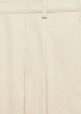 Pantalón amplio color beige con tiro alto y detalles de plisado en la parte frontal.