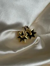Par de aros dorados con forma de estrella negra.