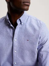 Camisa celeste de corte regular Tommy Hilfiger, confeccionada en algodón Oxford con microestampado de puntos azules. Tiene cuello abotonado, manga larga y logo bordado en el pecho.