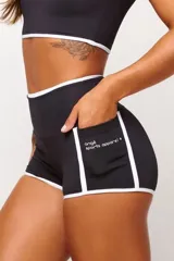 Short deportivo negro de cintura alta con ribete blanco y bolsillos laterales. Ideal para actividades al aire libre, cuenta con protección UV50+.