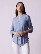 Blusa celeste texturada marca Ninety, con cuello a la base, escote en V y abertura central con botones. Delantera con bolsillo y mangas tres cuartos regulables con presilla y botón.