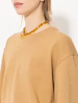 Buzo de punto color crema con lurex y mangas largas con puños ajustados.