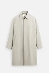 Gabardina color beige de corte relaxed fit, confeccionada en tejido italiano repelente al agua. Tiene cuello solapa, manga larga con puños abotonados, bolsillos de vivo en la cadera, bolsillo interior y abertura en la espalda.