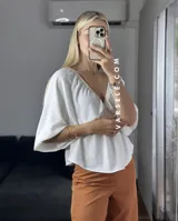 Blusa verde agua con escote en V, mangas cortas abullonadas y tiritas para atar.