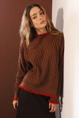 Sweater tejido rojo con cuello alto y puños con volados azules.