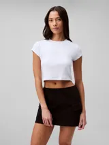 Remera corta blanca de algodón y elastano, con cuello redondo, mangas cortas y logo de Calvin Klein en el pecho.