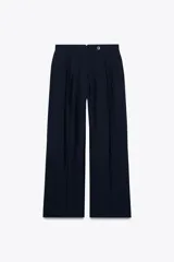 Pantalón de tiro medio color azul marino confeccionado en hilatura con mezcla de lyocell. Presenta bolsillos laterales, pinzas delanteras, pierna ancha y cierre frontal con cremallera y botón.