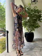 Vestido midi de gasa con estampado floral en tonos marrones, negros y violetas.