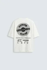 Camiseta blanca de corte holgado, cuello redondo y manga corta. Estampado frontal y trasero con gráficos y textos combinados en color negro.