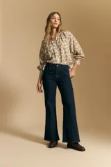 Jean oxford de tiro alto, color azul oscuro, con costuras frontales marcadas y corte acampanado progresivo desde la rodilla.