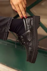 Mocasines negros de cuero con cordones y suela track.