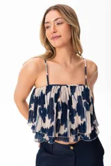 Top de gaza con estampado floral azul sobre fondo crudo, con tirantes finos y volados en el ruedo.