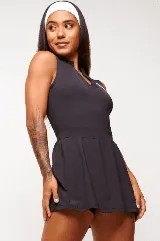 Vestido deportivo color verde con logo bordado en blanco en el pecho. Diseño sin mangas, con cuello mao y cierre parcial con botones. Falda con corte evasé y short interno.