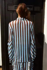 Camisa de tul elastizado con cuello solapa y abotonada, de mangas largas abullonadas con tiras para atar.