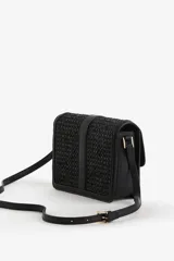 Bandolera negra con textura tejida, correa fina ajustable y solapa con cierre metálico dorado.