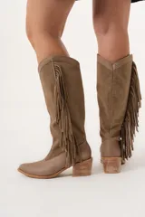Bota texana de caña alta color visón, 100% cuero hecha a mano en Uruguay, con cierre lateral y taco de 5,5 cm. Tiene flecos en los costados internos.