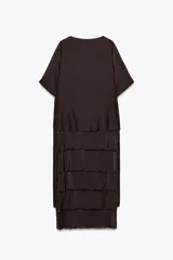 Vestido midi color marrón oscuro confeccionado en hilatura con viscosa y algodón. Tiene cuello redondo, manga corta y bajo con volantes desflecados y aberturas laterales.