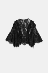 Camisa de encaje negra con cuello redondo y manga tipo capa con volantes.