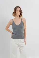 Musculosa amarilla de hilo con brillo sutil, de calce ajustado y breteles finos.