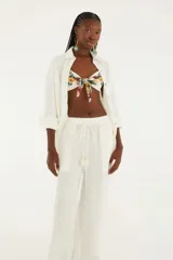 Pantalón marrón texturizado de corte holgado con piernas anchas y cinturilla con lazo personalizado.