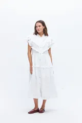 Vestido midi amarillo de lino, con volados en las mangas y detalle de volados y botones a lo largo del frente. Presenta un corte con talle marcado y falda escalonada.