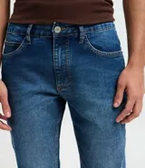 Pantalón de jeans azul de corte skinny, confeccionado con algodón, poliéster y elastano. Presenta un lavado medio con desgaste sutil y cierre tradicional.