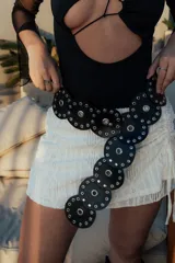 Minifalda blanca de tejido calado con cordones ajustables en los laterales.