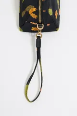 Neceser de nylon negro con estampado de cactus y flores naranjas. Tiene asa de mano desmontable, cierre con cremallera, bolsillo interior y logo metálico de Bimba y Lola.