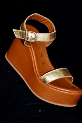 Sandalias de cuero color marrón con plataforma de madera y tira ancha sobre los dedos.