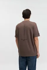 Remera marrón de manga corta con cuello redondo y estampado pequeño en el pecho.