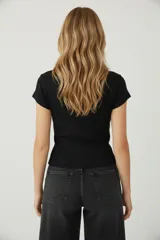 Saco de algodón y elastano, color negro, de corte al cuerpo, con cuello redondo y botones frontales.