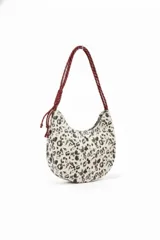 Cartera tipo media luna con estampado animal print en tonos blanco y negro, y asa de hombro trenzada en color bordó.