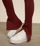 Pantalón deportivo tipo legging confeccionado en microfibra color bordó, con corte ajustado hasta la pantorrilla y terminación acampanada con abertura lateral.