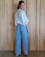 Pantalón de jean celeste de corte acampanado, con tiro alto y bolsillos delanteros y traseros.