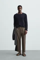 Pantalón negro de lino, corte recto y relaxed fit, con cintura elástica ajustable con cordón, bolsillos laterales y traseros.