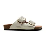 Sandalias bajas Korium Clarice de charol color blanco con hebillas doradas.